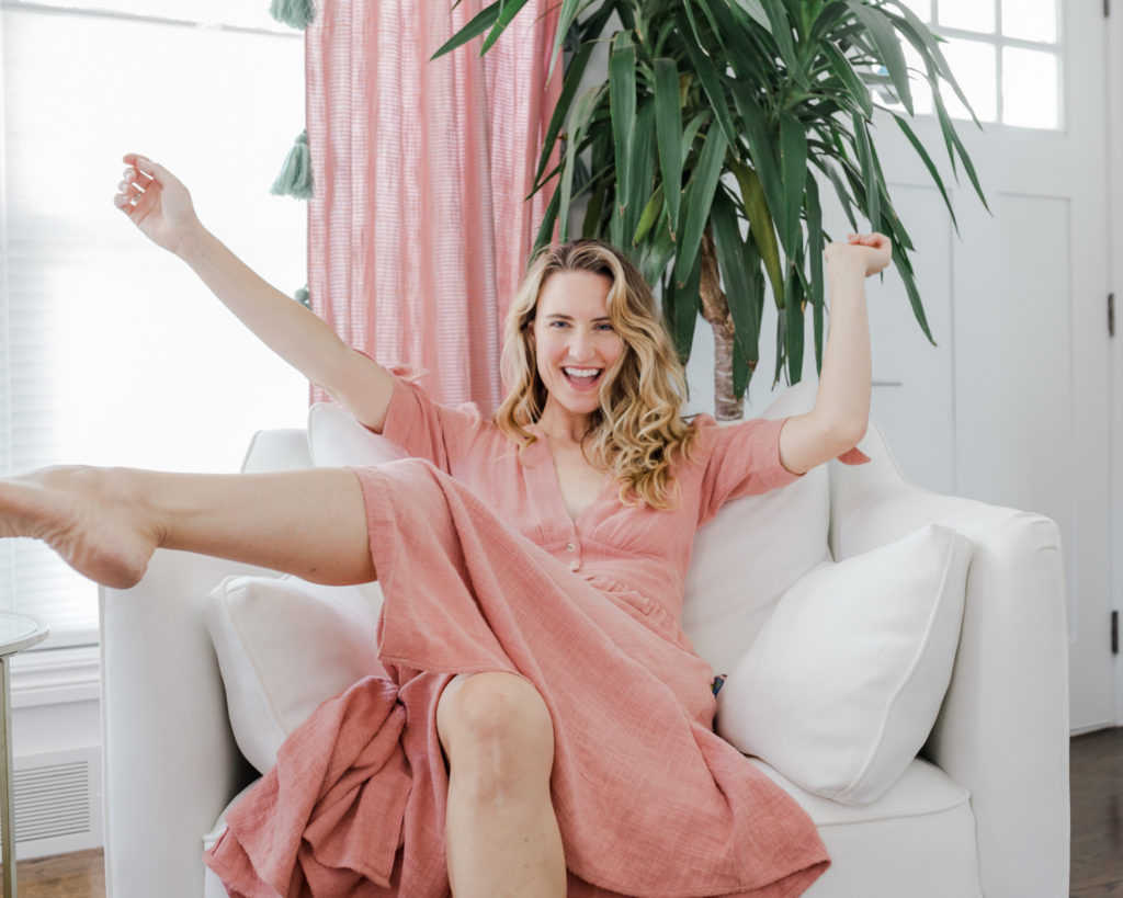 Happy and smiling on a white chair, Caitlin by The Everygirl chair